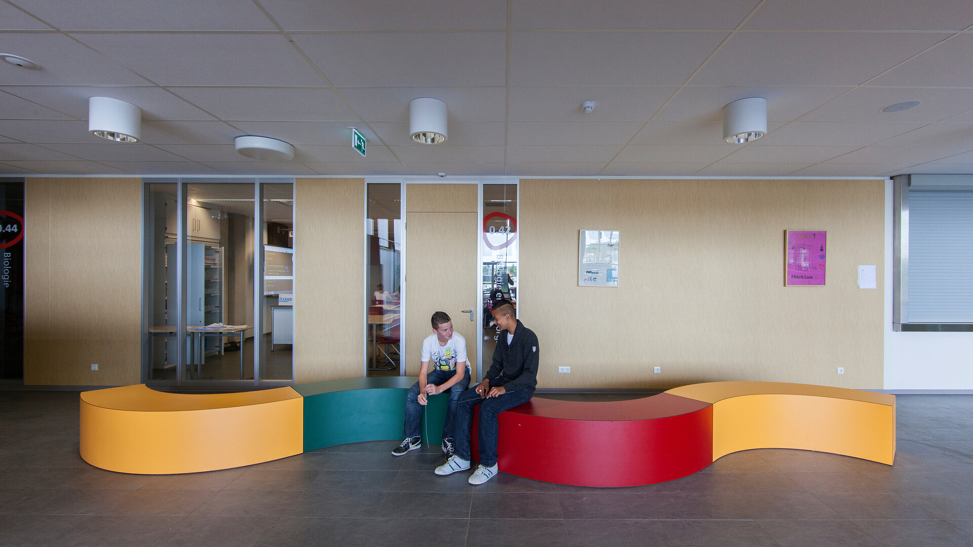 School children sit throughout a multiuse classroom space.